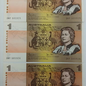 May include: Three Australian one-dollar banknotes. Each bill features a portrait of a woman, the text "AUSTRALIA", and a coat of arms with a kangaroo and emu. The serial numbers are visible.