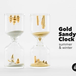 May include: Two gold hourglass sand timers, one with white sand and a snowman and pine tree, the other with gold sand and a palm tree and beach scene. The text "Gold Sandy Clock summer & winter" is below the hourglasses.