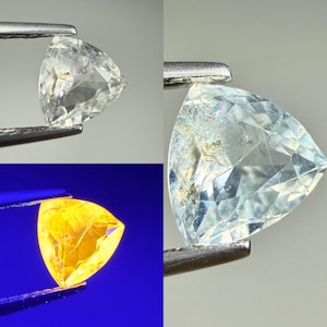 May include: A triangular faceted gemstone held by metal tweezers. The stone appears clear and colorless under standard lighting, displaying internal inclusions and facets. Under ultraviolet light, the same gemstone glows a vibrant yellow.
