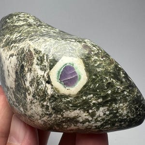 Rubí fluorescente natural pulido de 321 gramos con zoisita en biotita, de Pakistán.