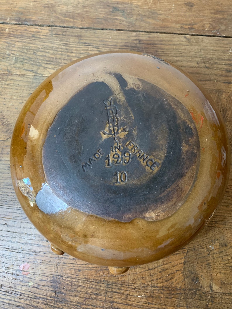 K&ouml;nnte beinhalten: Eine braune Keramiksch&uuml;ssel mit einem schwarzen Stempel auf der Unterseite, der "Made in France 1929 10" lautet.