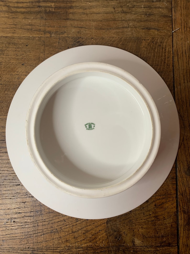 May include: White ceramic cake stand with a raised edge and a green mark on the bottom that reads "Made in Germany"