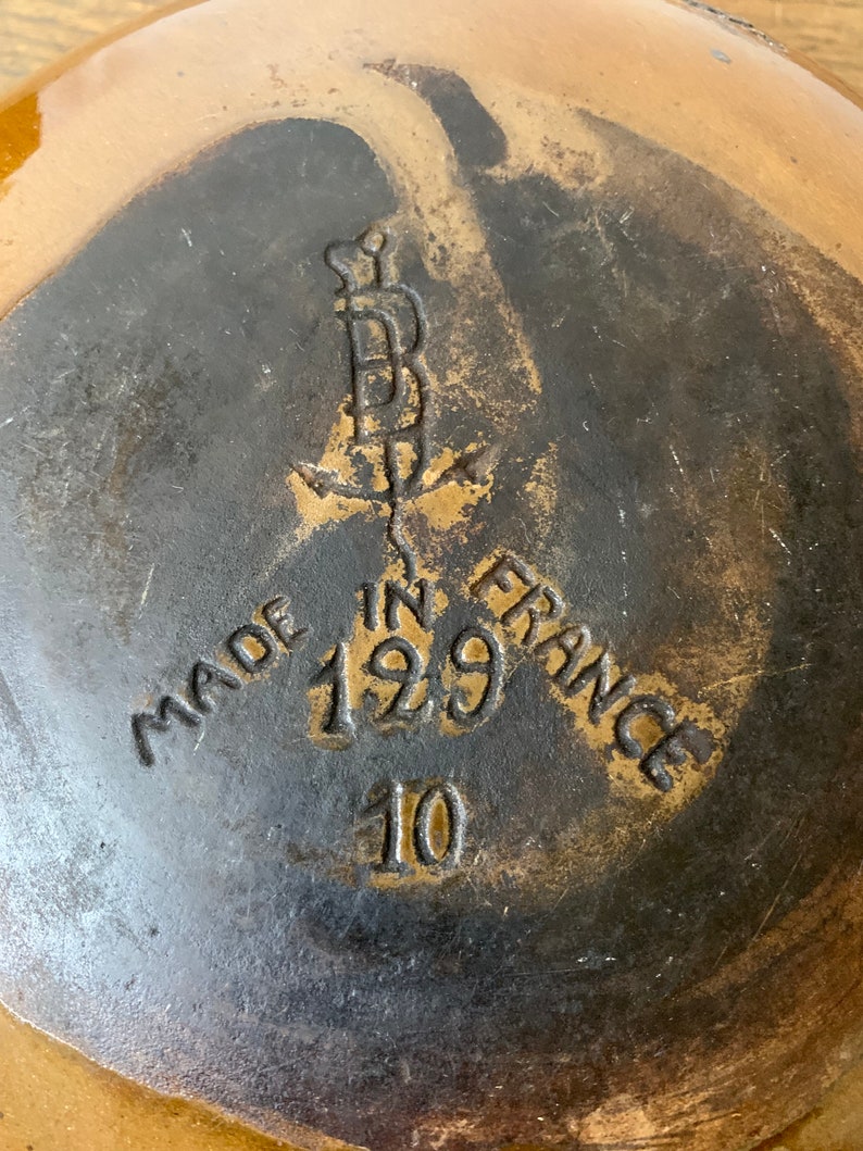 K&ouml;nnte beinhalten: Nahaufnahme des Bodens einer braunen Keramikschale mit schwarzer Glasur. Die Schale ist mit "Made in France 129 10" gekennzeichnet.