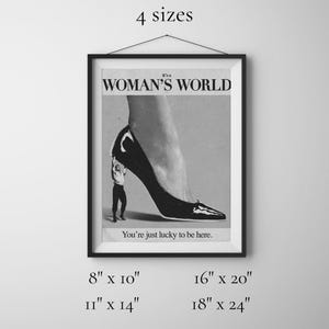 May include: Black and white framed print with the text "It's a WOMAN'S WORLD" and "You're just lucky to be here." The image depicts a high-heeled shoe with a small figure holding it up. Available in 4 sizes: 8" x 10", 11" x 14", 16" x 20", and 18" x 24".