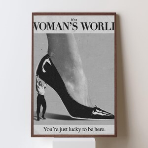 May include: Black and white framed print with the text "it's a WOMAN'S WORLD" and "You're just lucky to be here." The image features a high-heeled shoe and a small figure.