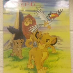 May include: A poster featuring characters from Disney's "The Lion King." The image shows Simba, Mufasa, and Zazu in a grassy landscape. The title "The Lion King" is displayed at the top. The poster has a light blue sky background.
