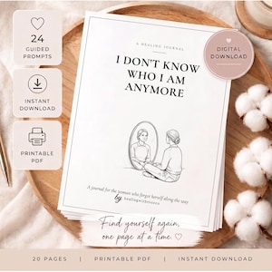 Peut inclure: Un journal en papier blanc intitulé I DON'T KNOW WHO I AM ANYMORE avec un dessin au trait d'une personne assise devant un miroir. La couverture inclut le texte A HEALING JOURNAL, A journal for the woman who forgot herself along the way, et by healingwithroseco.