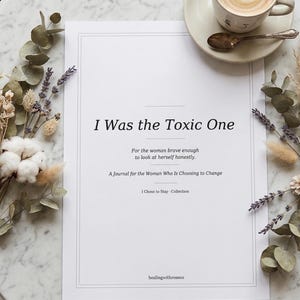 Peut inclure: Un journal blanc intitulé "I Was the Toxic One" avec le texte "Pour la femme assez courageuse pour se regarder honnêtement." et "Un journal pour la femme qui choisit de changer." Une tasse de café et des fleurs séchées sur une table en marbre.