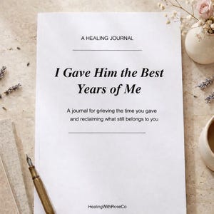 Può includere: Un diario bianco intitolato "I Gave Him the Best Years of Me" con il testo "A healing journal" in alto. Una penna e una pila di libri sono a sinistra. Un piccolo vaso con fiori è a destra.