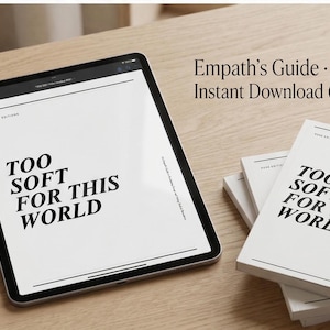 Puede incluir: Una tableta digital y varios libros con el texto "TOO SOFT FOR THIS WORLD" en negrita, en negro. También es visible la frase "Empath's Guide - Instant Download (PDF)". Los artículos están sobre una superficie de madera clara.
