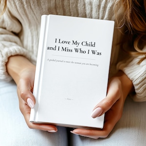 Peut inclure: Un journal à couverture rigide blanc avec le titre I Love My Child and I Miss Who I Was imprimé en noir sur la couverture, suivi du sous-titre A guided journal to meet the woman you are becoming et du nom Rose en bas.