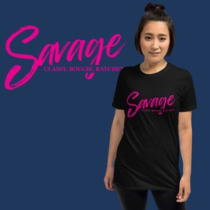 Op de afbeelding: Zwart T-shirt met een roze afbeelding met de tekst "Savage Classy, Bougie, Ratchet"