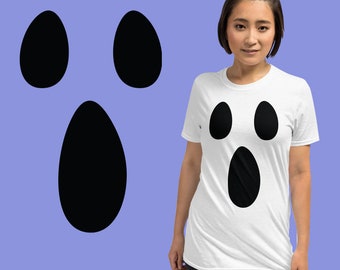 May include: A white t-shirt with a black ghost face design. The ghost has two eyes, a mouth, and a nose.
