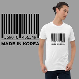 May include: White t-shirt with a black barcode and the text "569010 456549 MADE IN KOREA" printed on the front.
