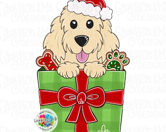 May include: A cartoon illustration of a golden retriever wearing a Santa hat, peeking out of a green gift box with a red bow. The box contains gingerbread cookies shaped like a bone and a paw print. The design has the text "Grayson & Me Designs".