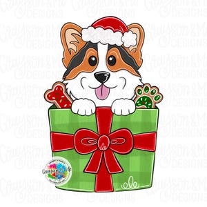 May include: A digital illustration of a Corgi dog wearing a Santa hat, peeking out of a green gift box tied with a red bow. The box contains a bone-shaped cookie and a paw print cookie. The image includes the text "Grayson & Me Designs".