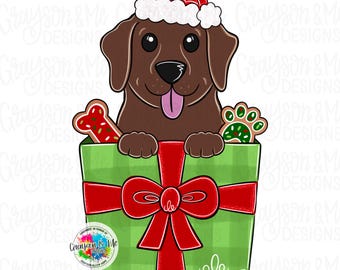 May include: A cartoon illustration of a brown Labrador wearing a Santa hat, peeking out of a green gift box with a red bow. The box contains a bone-shaped cookie and a paw-shaped cookie. The image includes the text "Grayson & Me Designs".