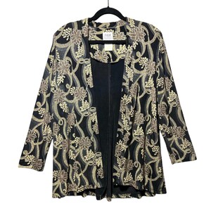 May include: Black open-front jacket with a floral pattern in shades of tan and gold. The jacket is hanging on a black hanger. The jacket has long sleeves and a black interior.