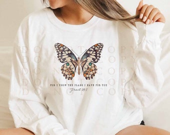 May include: White long-sleeve shirt with a butterfly graphic and the text "For I know the plans I have for you - Jeremiah 29:11".