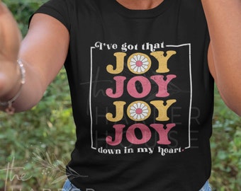 May include: Black t-shirt with a retro graphic design featuring the word "JOY" repeated four times with a daisy in each word. The text "I've got that" appears above the word "JOY" and the text "down in my heart" appears below the word "JOY".