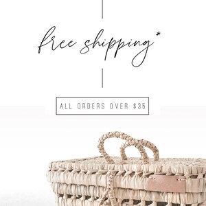 May include: A woven basket with a light brown color and two handles. The basket has a pink leather label on the side. The text "free shipping* ALL ORDERS OVER $35" is visible in the image.