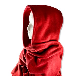 May include: A red fleece hooded scarf with a soft, warm texture. The scarf is designed to be worn around the neck and head, providing warmth and comfort during cold weather.