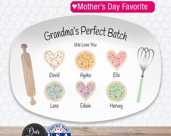 May include: White oval platter with the text "Grandma's Perfect Batch" and "We Love You." The platter features a rolling pin, whisk, and heart-shaped and round cookies with names. The words "Mother's Day Favorite" are at the top.