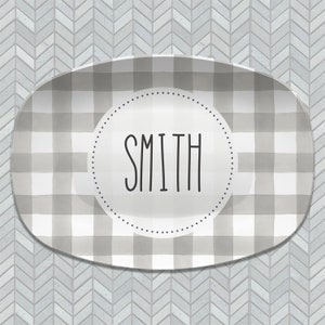 May include: A gray and white checkered oval serving platter with a white circle in the center that says "SMITH" in black lettering.