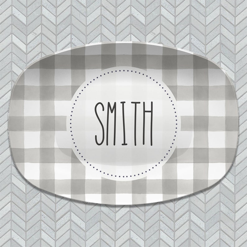 May include: A gray and white checkered oval serving platter with a white circle in the center that says "SMITH" in black lettering.
