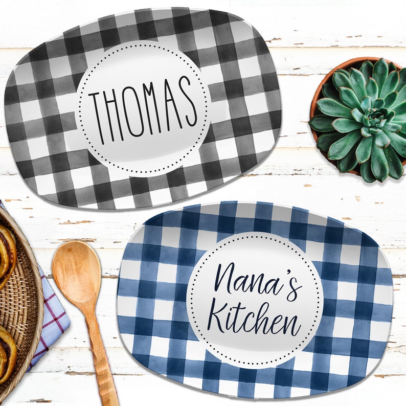 May include: Two oval serving platters with a checkered pattern. One platter is black and white and says "Thomas" in a circle. The other platter is blue and white and says "Nana's Kitchen" in a circle.