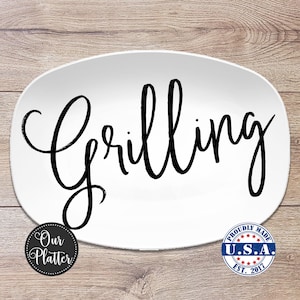 May include: White oval platter with the word "Grilling" in large, black cursive script. The platter has a black and white circular logo that says "Our Platter" and a blue, white, and red circular logo that says "Proudly Made U.S.A. Est. 2017".