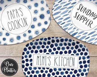 May include: Three blue and white oval serving platters with different watercolor designs. The platters feature the text "Papa's Cookin'," "Mimi's Kitchen," and "Sunday Supper."