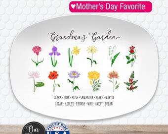 May include: White oval platter with a floral design and the words "Grandma's Garden." The platter features colorful illustrations of various flowers and the names of family members. The text "Mother's Day Favorite" is also displayed.