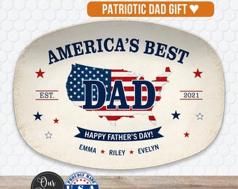May include: An oval ceramic serving platter with a cream-colored base. The center features a map of the United States filled with a red, white, and blue flag pattern. Text reads: AMERICA'S BEST DAD, EST. 2021, HAPPY FATHER'S DAY, EMMA, RILEY, EVELYN.