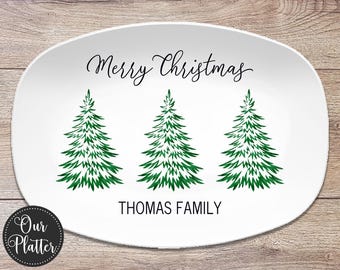 May include: White oval serving platter with a green Christmas tree design and the text "Merry Christmas" and "Thomas Family".
