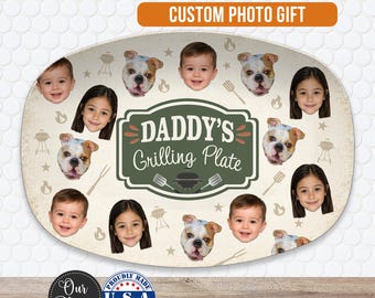 May include: An oval-shaped serving platter featuring a central green label with the text "DADDY'S Grilling Plate" surrounded by illustrations of grilling tools, flames, and stars, interspersed with multiple photographs of children and bulldogs.