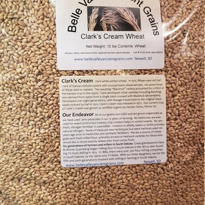 May include: A close-up of a bag of Clark's Cream Wheat, a hard white winter wheat. The bag is labeled with the company's website and contact information. The wheat is organically grown and non-GMO. The bag contains 15 pounds of wheat.