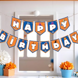 May include: A festive birthday banner with orange and blue pennants spelling "HAPPY BIRTHDAY". The banner is strung across a white background, with decorative paper flowers and a blue honeycomb ball. The overall theme is a birthday celebration.