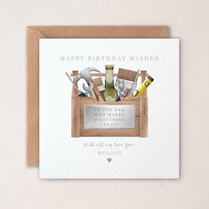 May include: A birthday card with a brown envelope. The card features a wooden toolbox filled with tools and a bottle. Text reads "HAPPY BIRTHDAY WISHES" and "TO THE DAD WHO MAKES EVERYTHING GREAT!" with a heart and the name "MELODY".