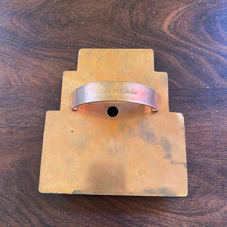 May include: A gold-colored metal cookie cutter shaped like a tiered cake with a handle that reads "SPECIAL OCCASION".