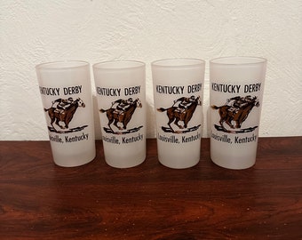 Puede incluir: Conjunto de cuatro vasos de vidrio esmerilado con temática del Derby de Kentucky. Cada vaso presenta un caballo marrón y un jinete con el texto "Kentucky Derby" y "Louisville, Kentucky".
