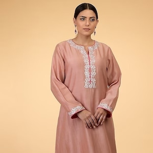 Met een geperste roze kaftan in katoenen zijdebasis met borduursel.