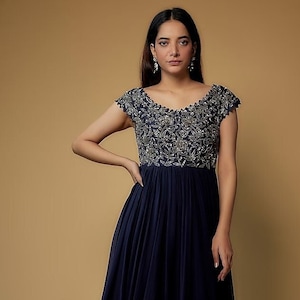 Featuring a navy blue dress in dola silk, cotton, shantoon, and georgette base with embroidery. Perfect wear for festive occasions