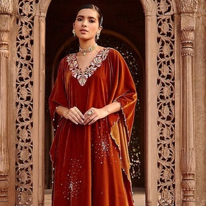 Featuring a honey gold kaftan in velvet base with hand embroidery. It is paired with matching pearl beaded pants.