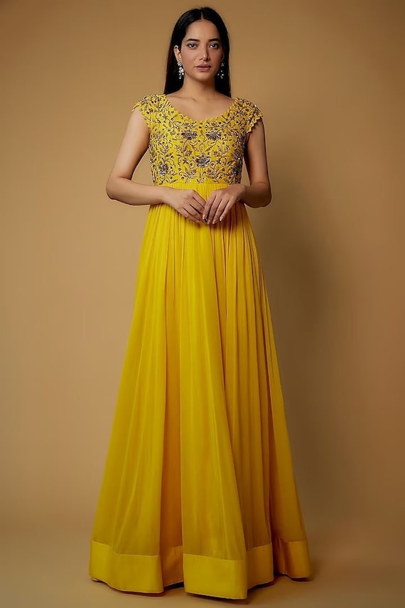 Met een gele jurk in dola-zijde, katoen, shantoon en georgette