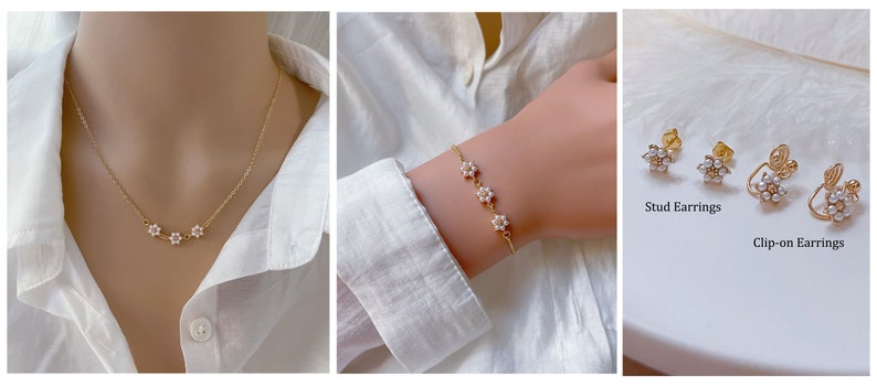 May include: A set of delicate gold jewelry featuring a necklace, bracelet, and earrings with small pearl flower accents. The earrings are available in both stud and clip-on styles.