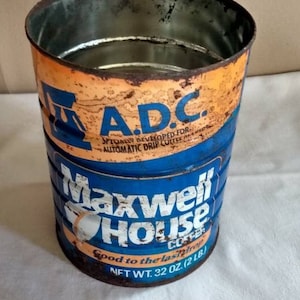 May include: A blue and orange vintage coffee can with the text "A.D.C. Specially Developed for Automatic Drip Coffee" and "Maxwell House Coffee Good to the Last Drop Net Wt. 32 oz. (2 lb)"