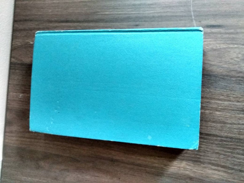 K&ouml;nnte beinhalten: Ein t&uuml;rkisfarbenes Hardcover-Buch mit einem glatten, strukturierten Einband.
