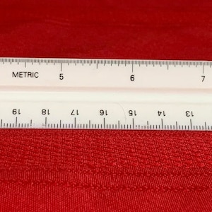 May include: A white plastic ruler with black markings. The ruler is 12 inches long and has both inch and metric markings. The ruler is labeled "Alvin No. 1177 PM".