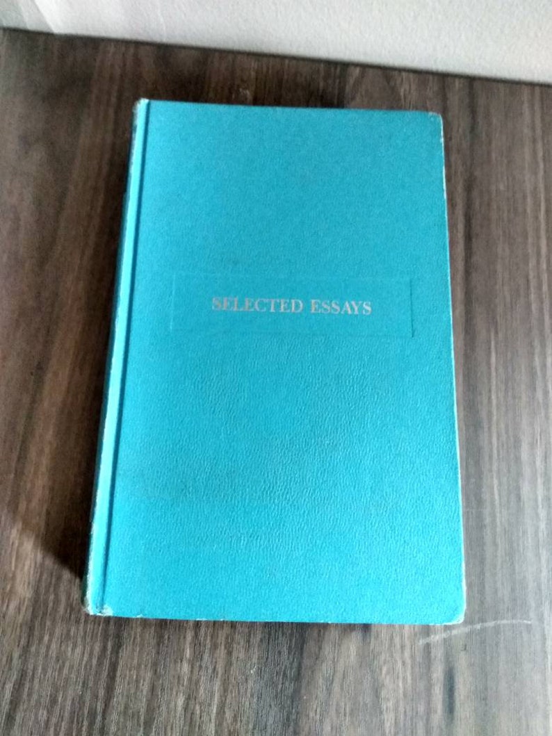K&ouml;nnte beinhalten: Ein tealblaues Hardcover-Buch mit dem Titel "SELECTED ESSAYS" in silbernen Lettern auf dem Einband.